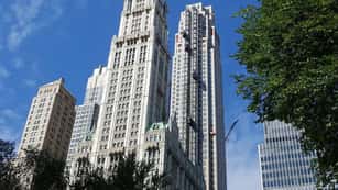A high rise in Manhattan at 30 Park Place, with blue sky in the background and trees framing the photo.