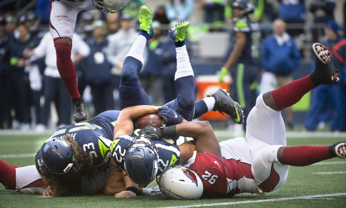 Seattle Seahawks quarterback Russell Wilson stiff arms Tampa Bay Buccaneers  cornerback Michael Adams (21) on his way to a first down in the third  quarter at CenturyLink Field in Seattle, Washington on