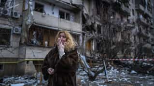 Natali Sevriukova reacts next to her house following a rocket attack