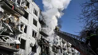 Firefighters work on a fire on a building after bombings on the eastern Ukraine town of Chuguiv on February 24, 2022, as Russian armed forces are trying to invade Ukraine from several directions, u...