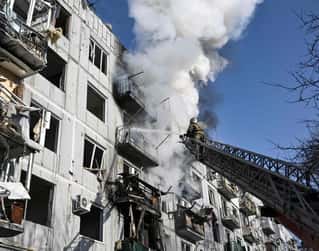 Firefighters work on a fire on a building after bombings on the eastern Ukraine town of Chuguiv on February 24, 2022, as Russian armed forces are trying to invade Ukraine from several directions, u...