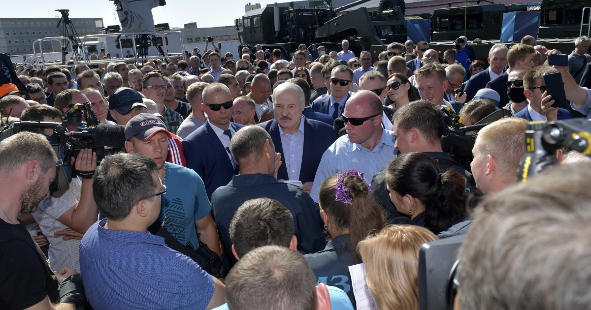 Belarusian President Alexander Lukashenko, center, surrounded by his bodyguards listens to an employee of the Minsk Wheel Tractor Plant in Minsk, Belarus, Monday, Aug. 17, 2020. Workers heckled Pre...