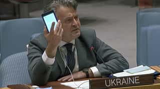 In this image from UNTV video, Ukraine's Ambassador to the United Nations Sergiy Kyslytsya, holds up a phone as he speaks an emergency meeting of the U.N. Security Council Wednesday, Feb. 23, 2022,...