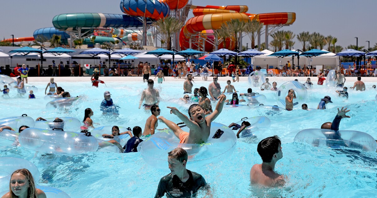 IRVINE, CA - JULY 13: DJ Yokoyama, 11, center, of Mission Viejo, and guests ride the waves at Shaka Bay wave pool at the soft opening of Wild Rivers water park at the Great Park on Wednesday, July ...